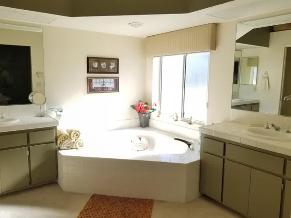 a bathroom with a tub sink and mirror