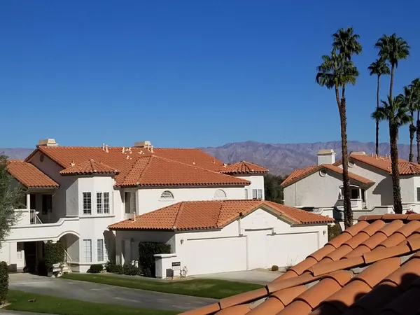 a view of houses with yard and car parked