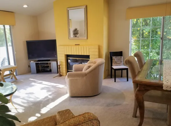 a living room with furniture a flat screen tv and a fireplace