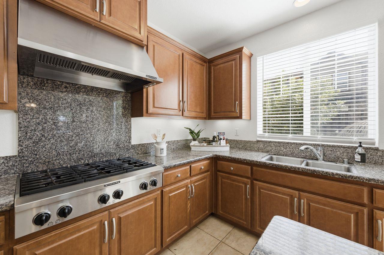 698 West Rico Way Tracy, CA 95391 - Photo 14 of 38 a kitchen with a sink stove and cabinets