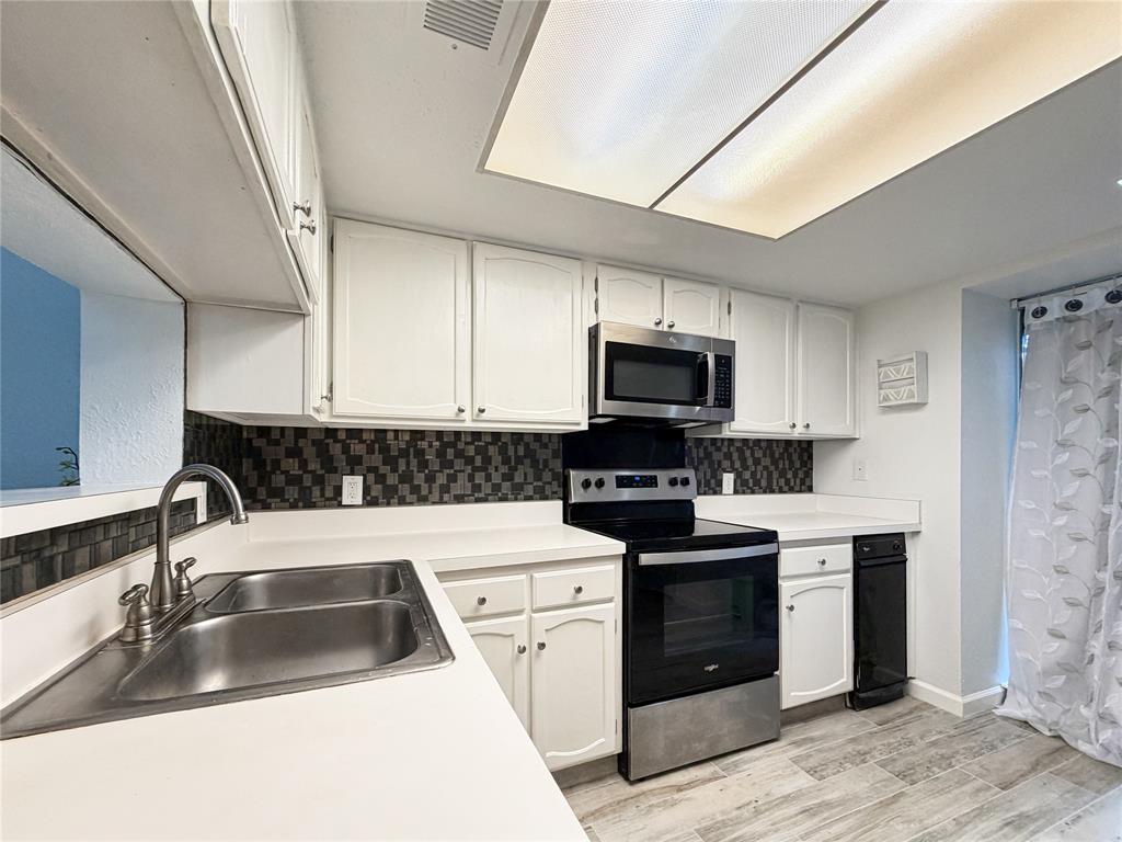 4565 North O'Connor Road, Unit 1304 Irving, TX 75062 - Photo 9 of 32 Kitchen featuring white cabinetry, a dual basin stainless steel sink, and wood-finish flooring
