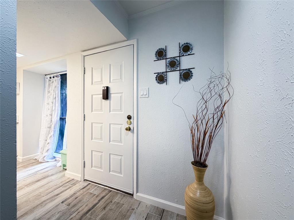 4565 North O'Connor Road, Unit 1304 Irving, TX 75062 - Photo 11 of 32 Entryway featuring wood-finish flooring and a paneled white door