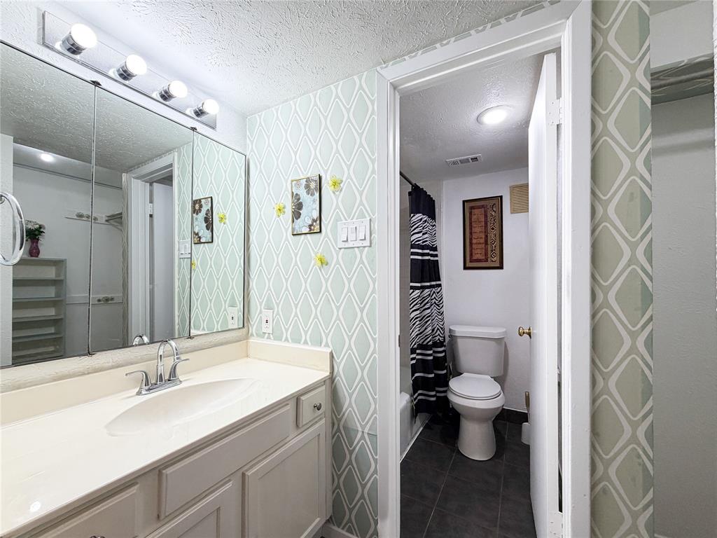 4565 North O'Connor Road, Unit 1304 Irving, TX 75062 - Photo 16 of 32 Primary Bathroom vanity featuring a single basin sink set into a light-toned countertop, a tri-panel mirror
