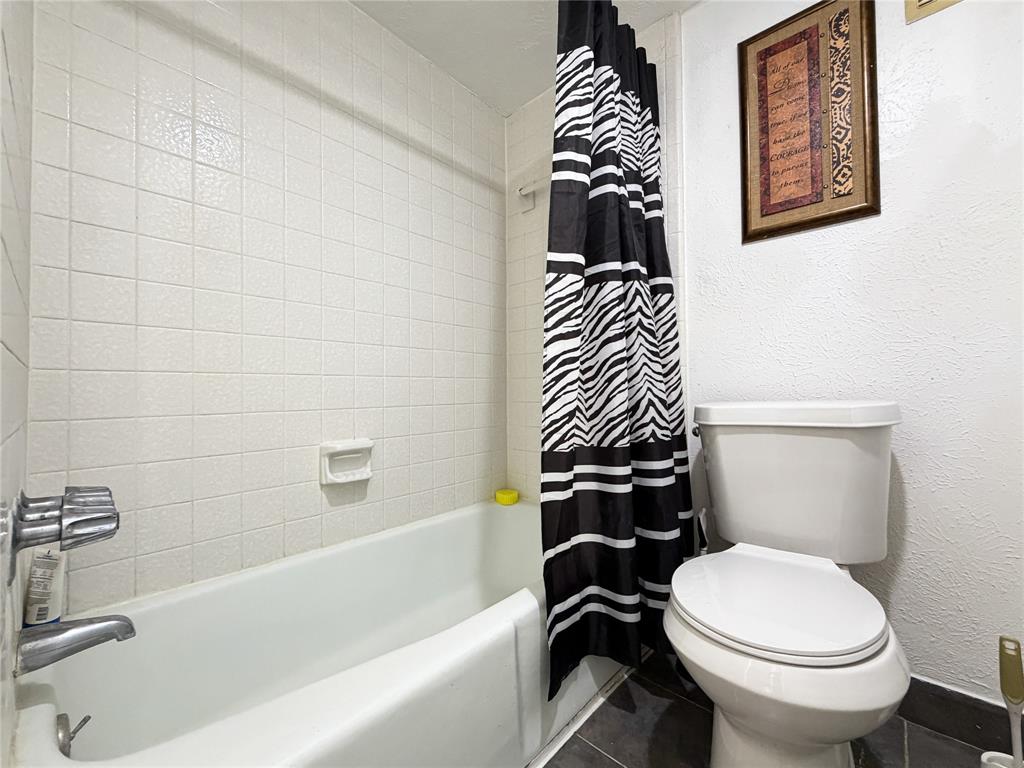 4565 North O'Connor Road, Unit 1304 Irving, TX 75062 - Photo 17 of 32 Full-size bathtub with chrome fixtures, white square tile surround, and a white toilet