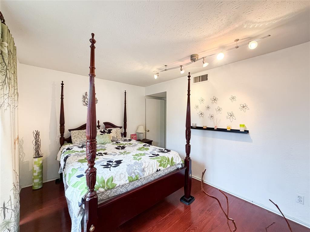 4565 North O'Connor Road, Unit 1304 Irving, TX 75062 - Photo 21 of 32 Bedroom featuring laminate flooring, track lighting, and a window