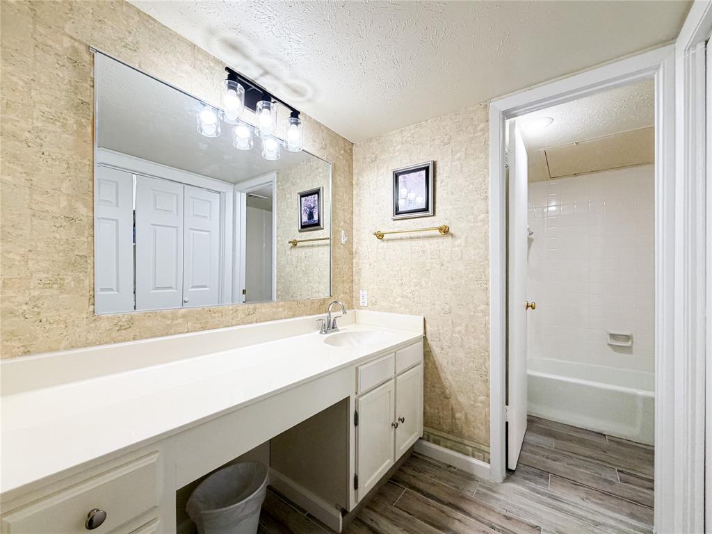 4565 North O'Connor Road, Unit 1304 Irving, TX 75062 - Photo 23 of 32 Bathroom featuring an extended vanity with an integrated sink, white cabinetry, and a large wall-mounted mirror