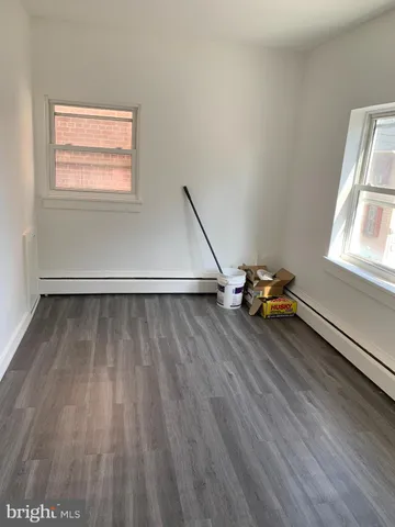 an empty room with wooden floor and a window