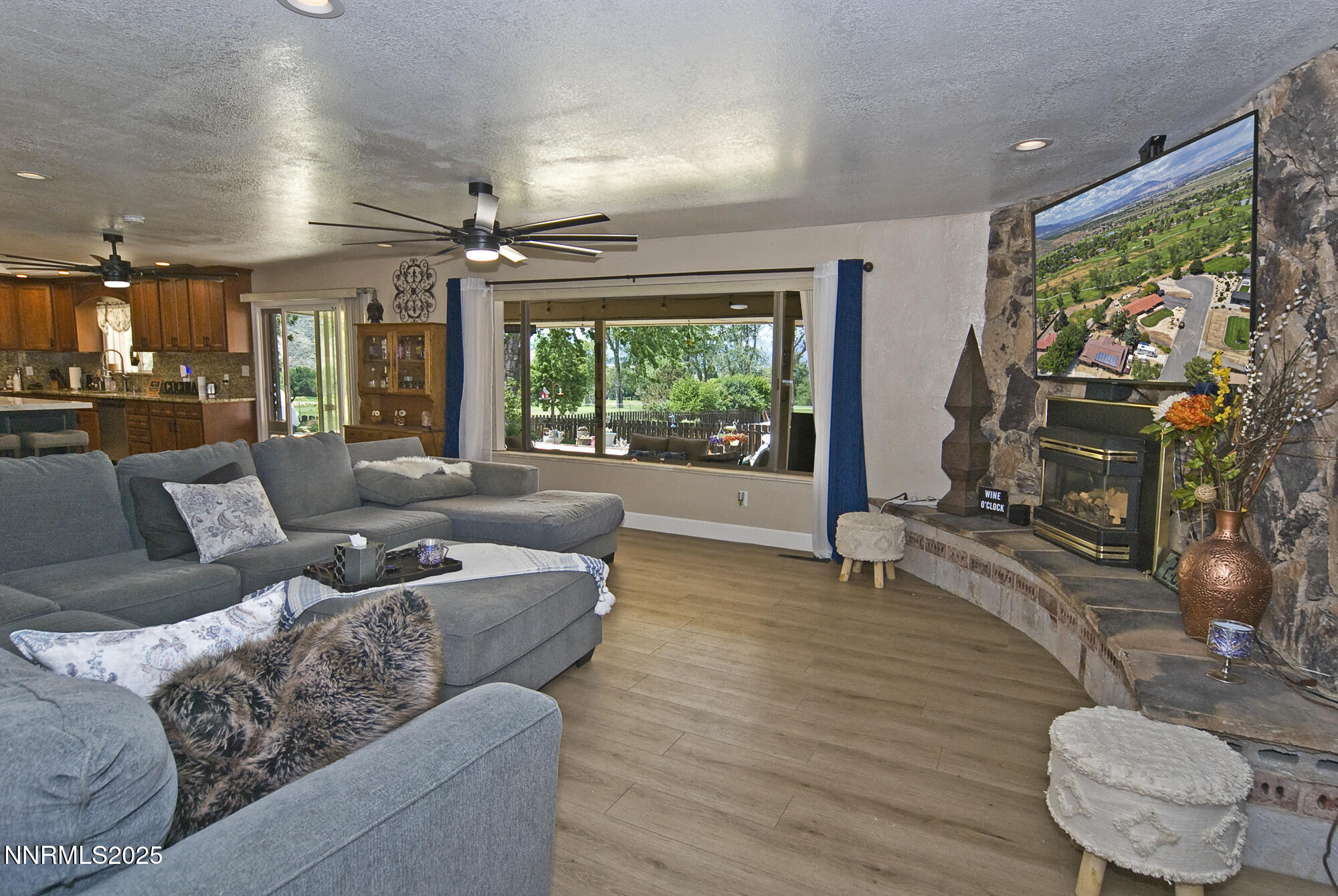 5705 Blue Hills Drive Reno, NV 89502 - Photo 22 of 56 a living room with furniture a flat screen tv and a floor to ceiling window