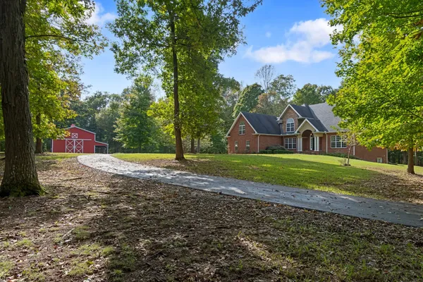 a view of house with backyard space and garden