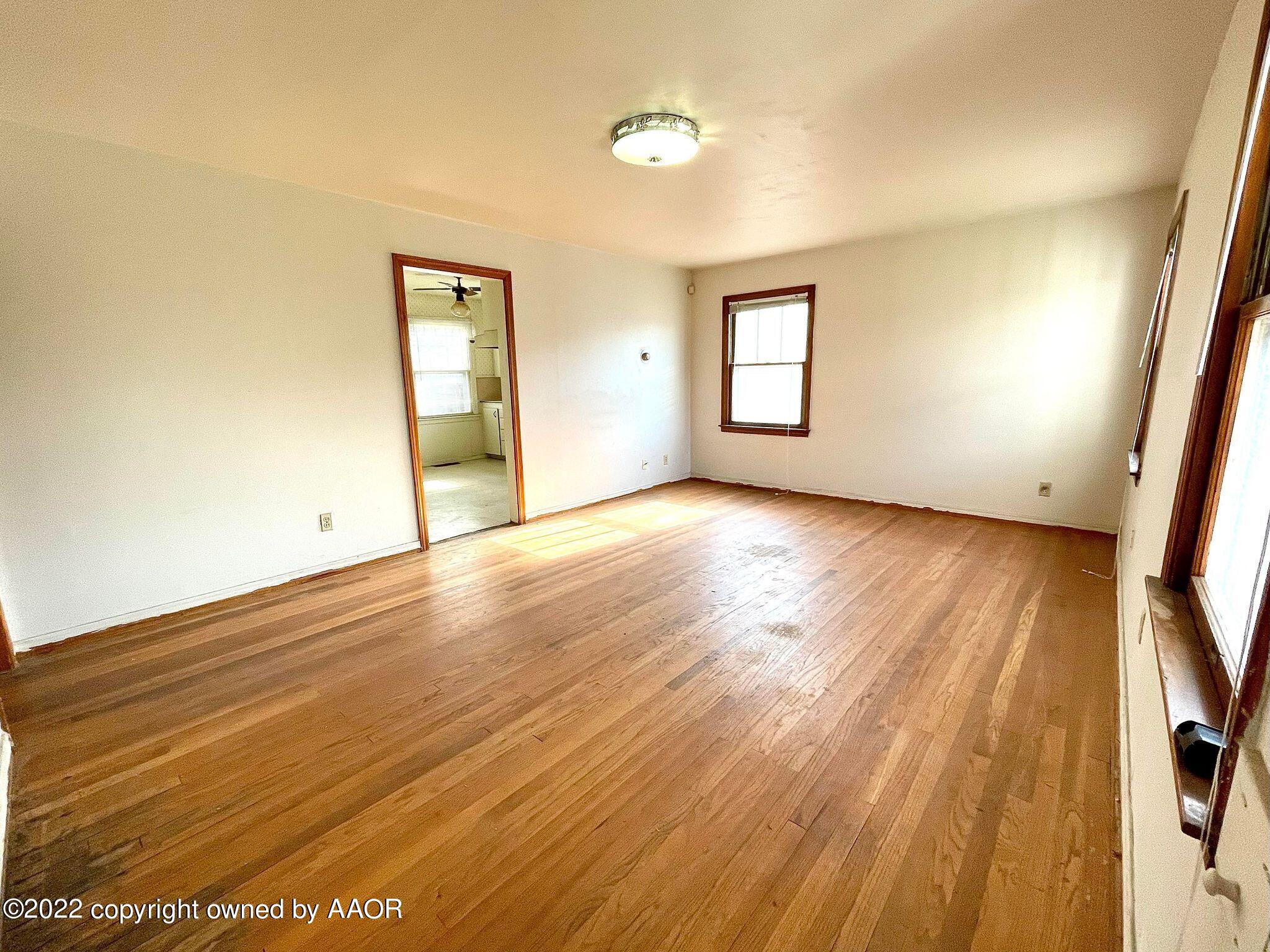 702 Sunset Terrace Amarillo, TX 79106 - Photo 4 of 21 an empty room with wooden floor and windows