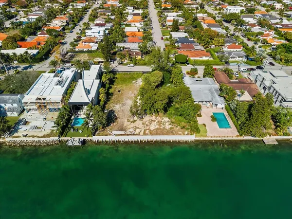 an aerial view of residential houses with outdoor space and trees