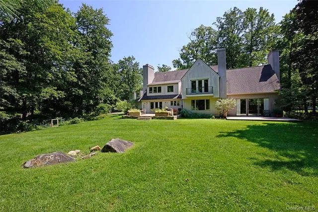a front view of a house with a yard table and trees