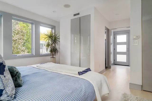 a bedroom with a bed and a large window