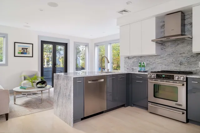 a kitchen with granite countertop a stove a sink and a window