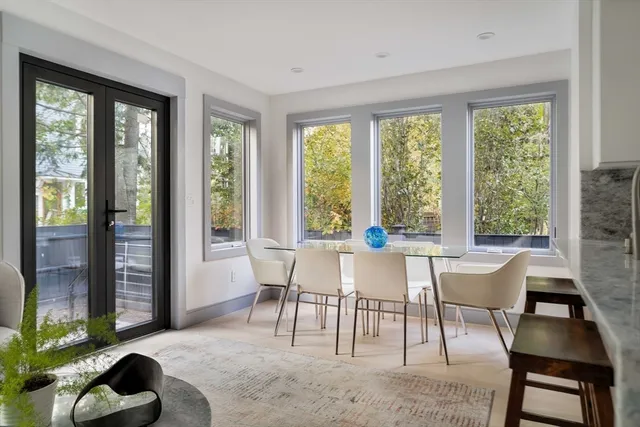a dining room with furniture and large windows