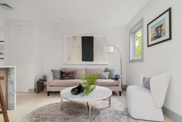 a living room with furniture and a painting on the wall