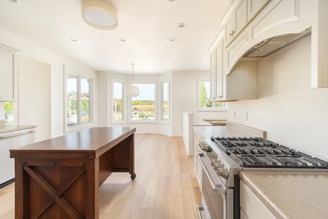 a kitchen with a stove a sink a dining table and chairs