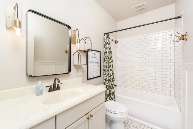 a bathroom with a granite countertop sink toilet and shower