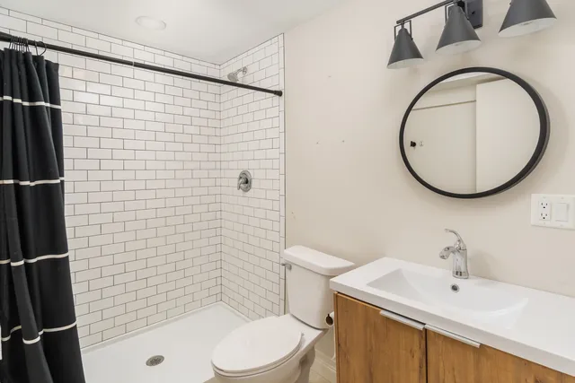 a bathroom with a sink a toilet and shower