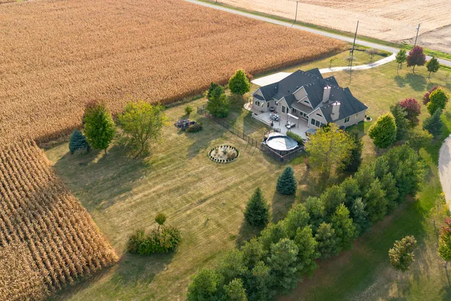 a view of a large house with a big yard and large trees