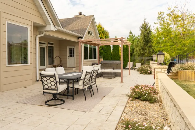 a view of a patio with table and chairs with wooden floor and fence