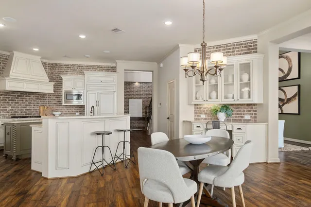 a dining room with furniture a chandelier and wooden floor