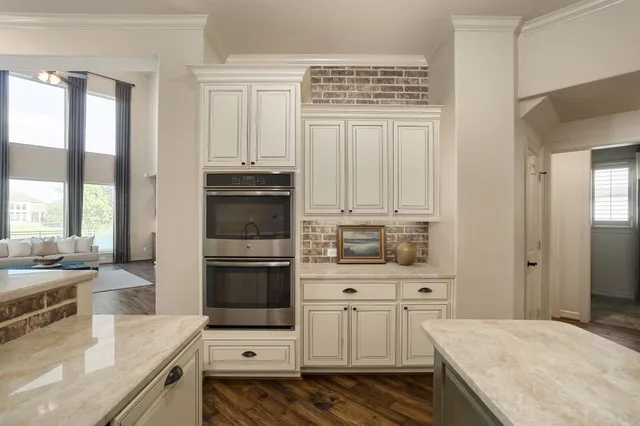 a kitchen with stainless steel appliances kitchen island granite countertop a stove a sink and a refrigerator with wooden cabinets