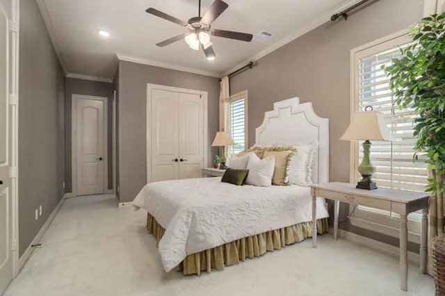 a bedroom with a bed chandelier and a window