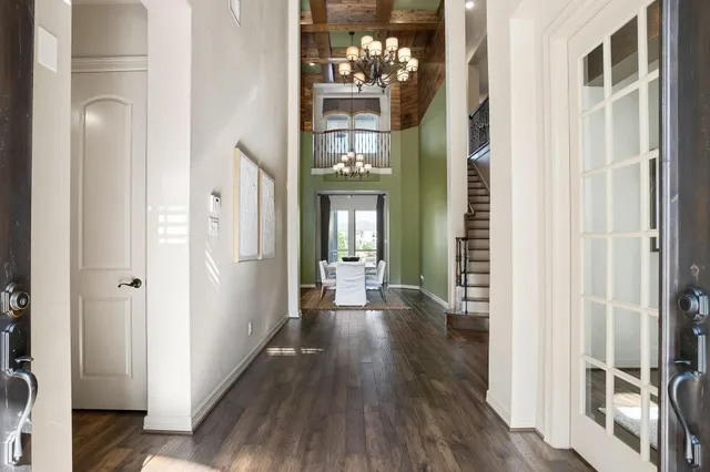 a view of a hallway with wooden floor and a living room