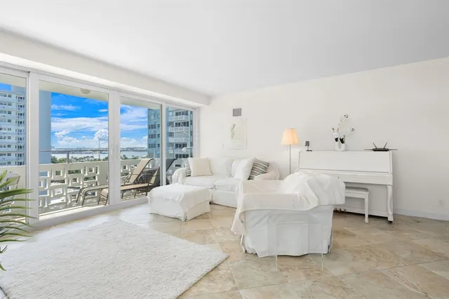 a living room with furniture and a floor to ceiling window