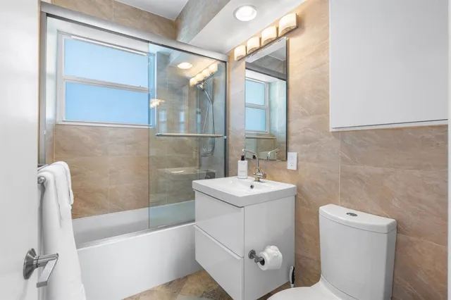 a bathroom with a sink a toilet a tub and shower