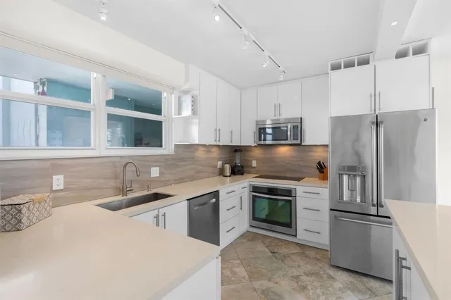 a kitchen with stainless steel appliances a sink stove and refrigerator