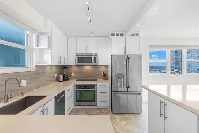 a kitchen with kitchen island a sink appliances and cabinets
