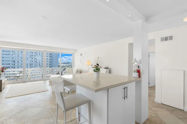 a dining hall with stainless steel appliances granite countertop a granite counter tops and white cabinets