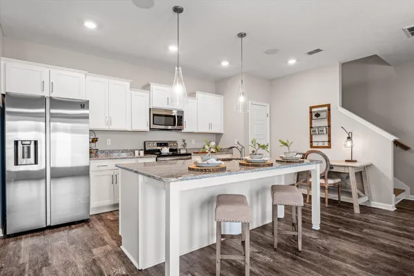 a kitchen with kitchen island a sink counter and chairs