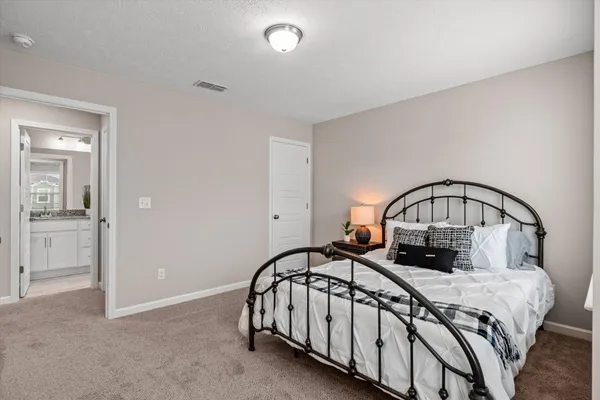 a bedroom with a bed a mirror with the dresser