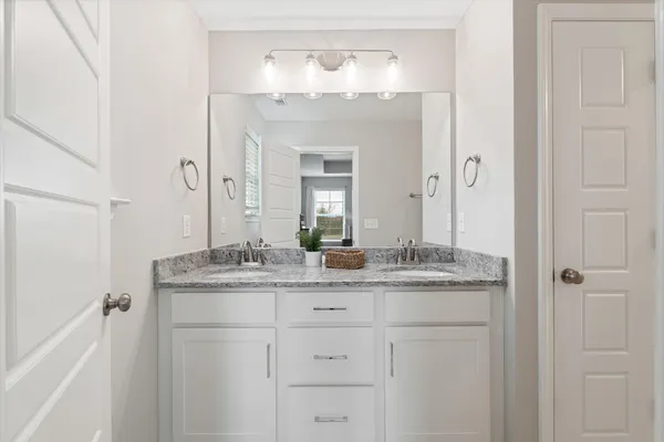 a bathroom with a granite countertop sink vanity and a mirror
