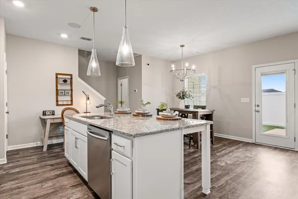 a kitchen with stainless steel appliances granite countertop a sink a stove and a wooden floors