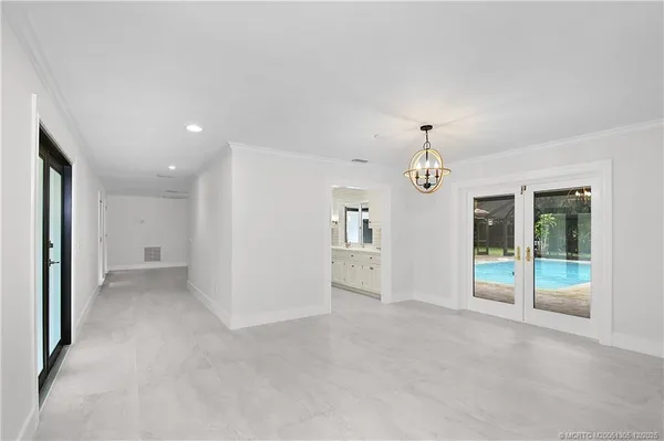 a large white kitchen with granite countertop a sink and a refrigerator