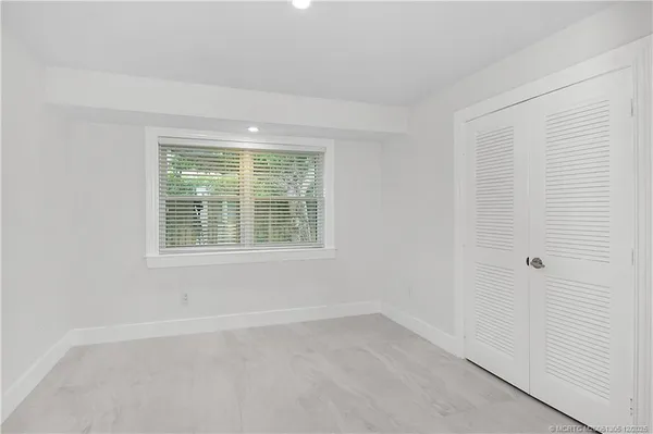 an empty room with windows and closet