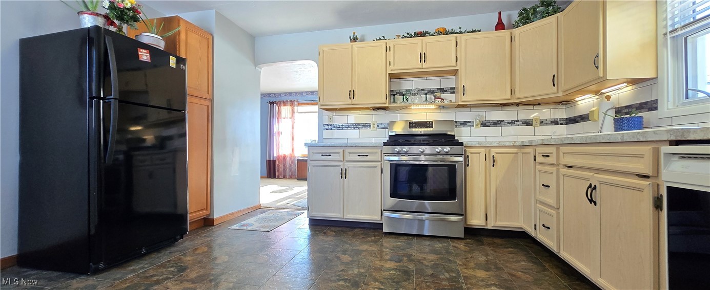 5217 McCartney Road Sandusky, OH 44870 - Photo 3 of 17 Kitchen featuring decorative backsplash, stainless steel range, and black refrigerator