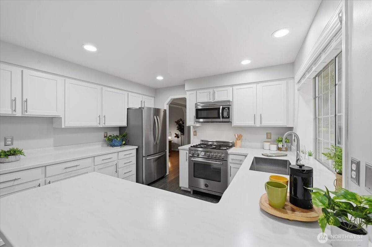 13802 60th Avenue West Edmonds, WA 98026 - Photo 15 of 36 a kitchen with a refrigerator a stove top oven a sink and cabinets