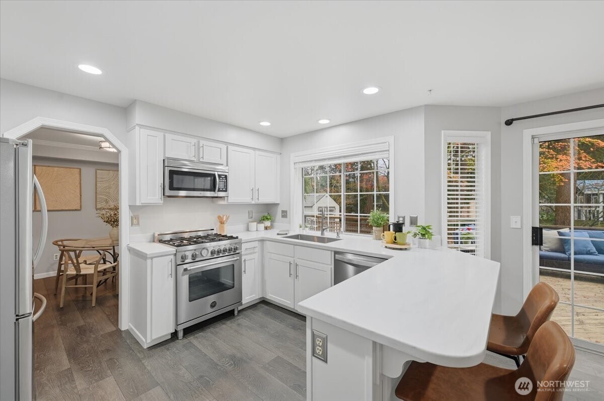 13802 60th Avenue West Edmonds, WA 98026 - Photo 17 of 36 a kitchen with a stove a sink a microwave a dining table and chairs