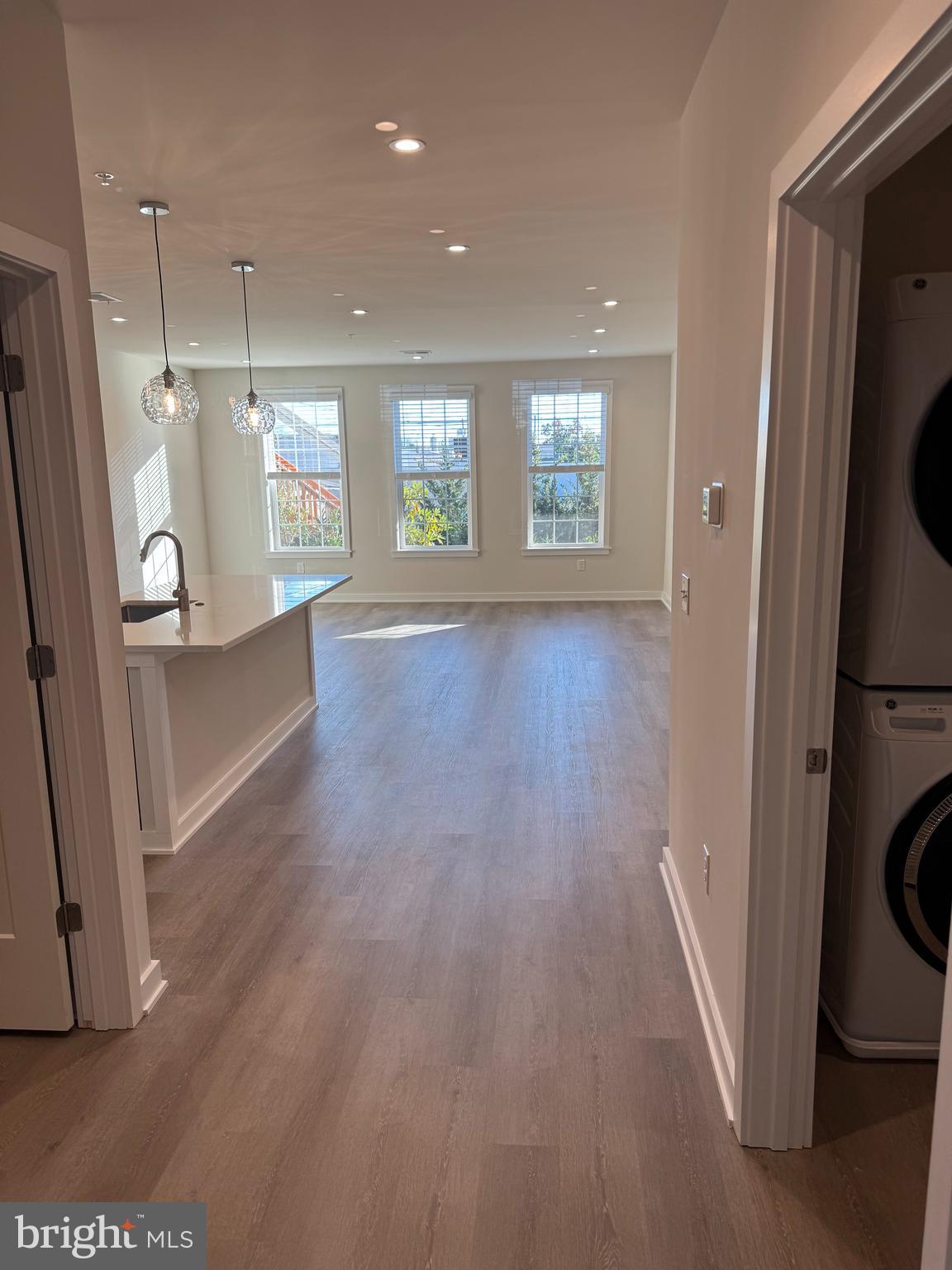a view of a big room with wooden floor and windows