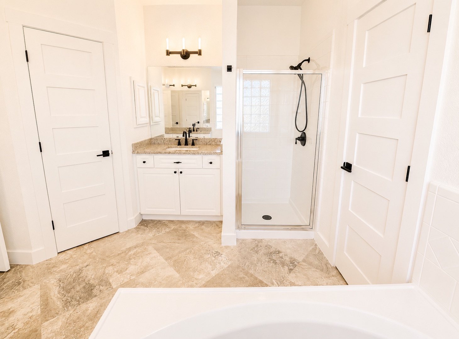 1610 Juniper Ridge Loop Cedar Park, TX 78613 - Photo 18 of 28 Polished stone tile flooring anchors a light-filled bath featuring a glass-enclosed shower and classic cabinetry.