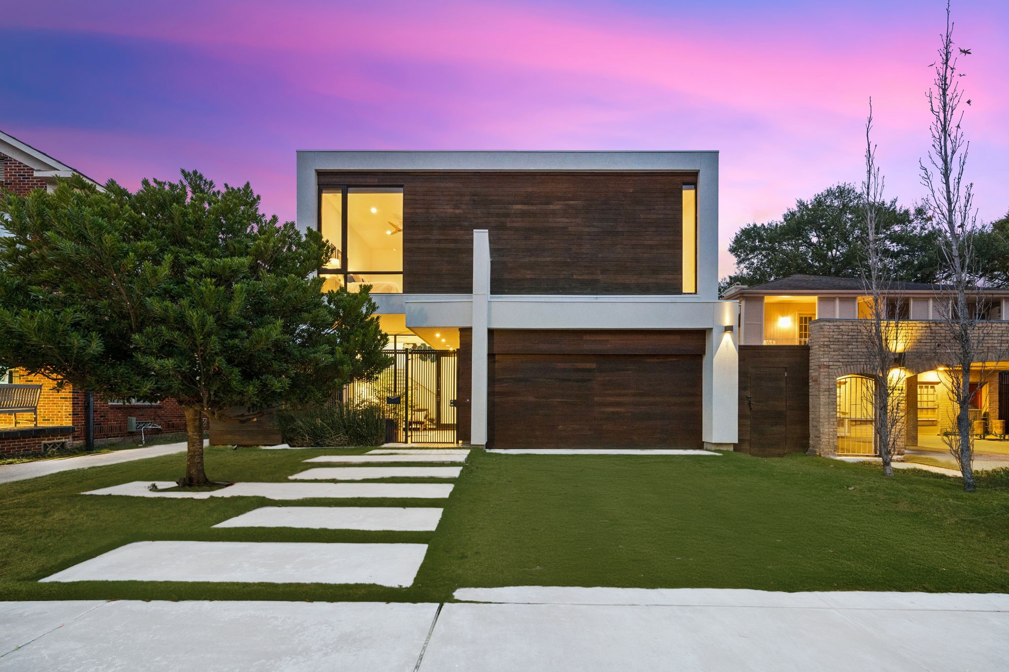 2332 Wroxton Road Houston, TX 77005 - Photo 2 of 50 Sleek wood accents and expansive steel-framed glass create a striking backdrop to the private pool and lounging deck, seamlessly blending indoor and outdoor living. Cozy up around the poolside fire pit or unwind in the tranquil yard—ideal for sophisticated entertaining or relaxed evenings at home.