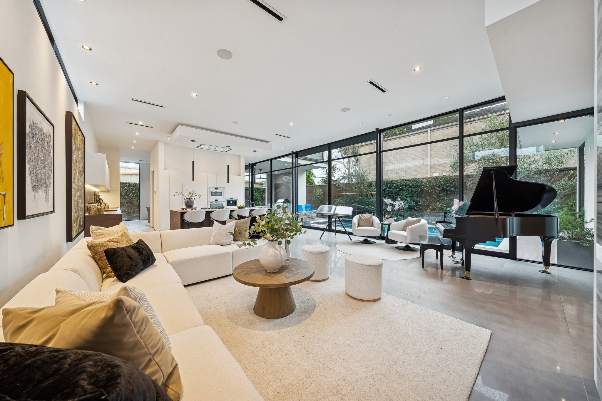 2332 Wroxton Road Houston, TX 77005 - Photo 3 of 50 Showcasing bold architectural lines and a sophisticated stucco exterior, the front elevation is highlighted by modern wood accents and expansive steel-framed glass. A gated courtyard, elegant covered entry, and designer landscaping create a private, luxurious welcome, complemented by a double-wide driveway and two-car garage.