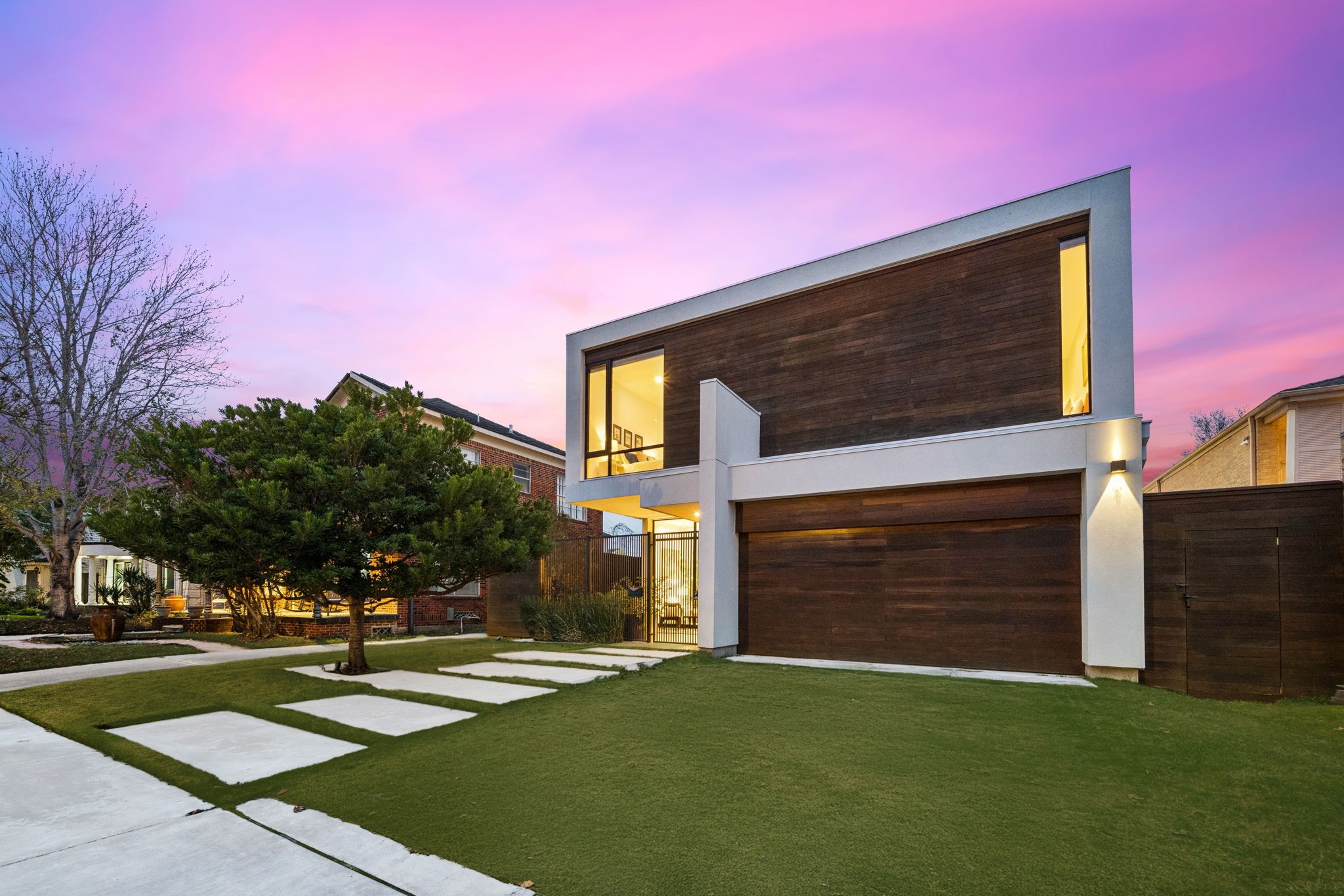 2332 Wroxton Road Houston, TX 77005 - Photo 5 of 50 Sleek and sophisticated, the gourmet kitchen impresses with an oversized island, professional-grade appliances, double ovens, and expansive cabinetry featuring custom appliance centers and soft-close drawers. Floor-to-ceiling windows offer seamless views of the patio and outdoor kitchen, while designer pendants and modern finishes create a culinary space ideal for both entertaining and everyday living.