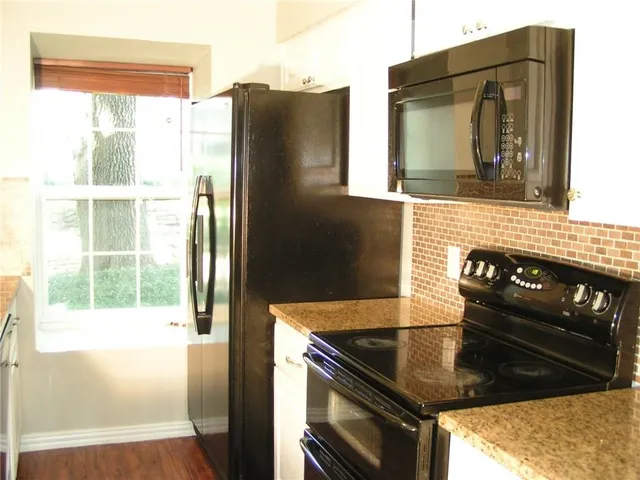 a kitchen with a refrigerator and a stove