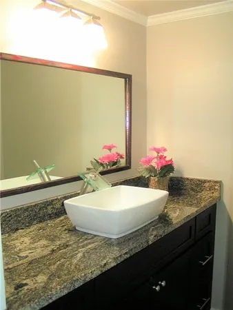 a bathroom with a granite countertop sink and a mirror